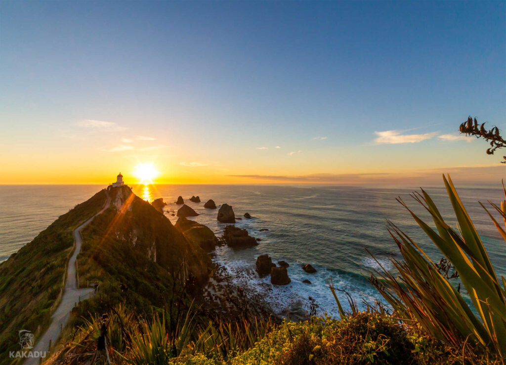 Latarnia Nugget Point na tle wschodzącego słońca